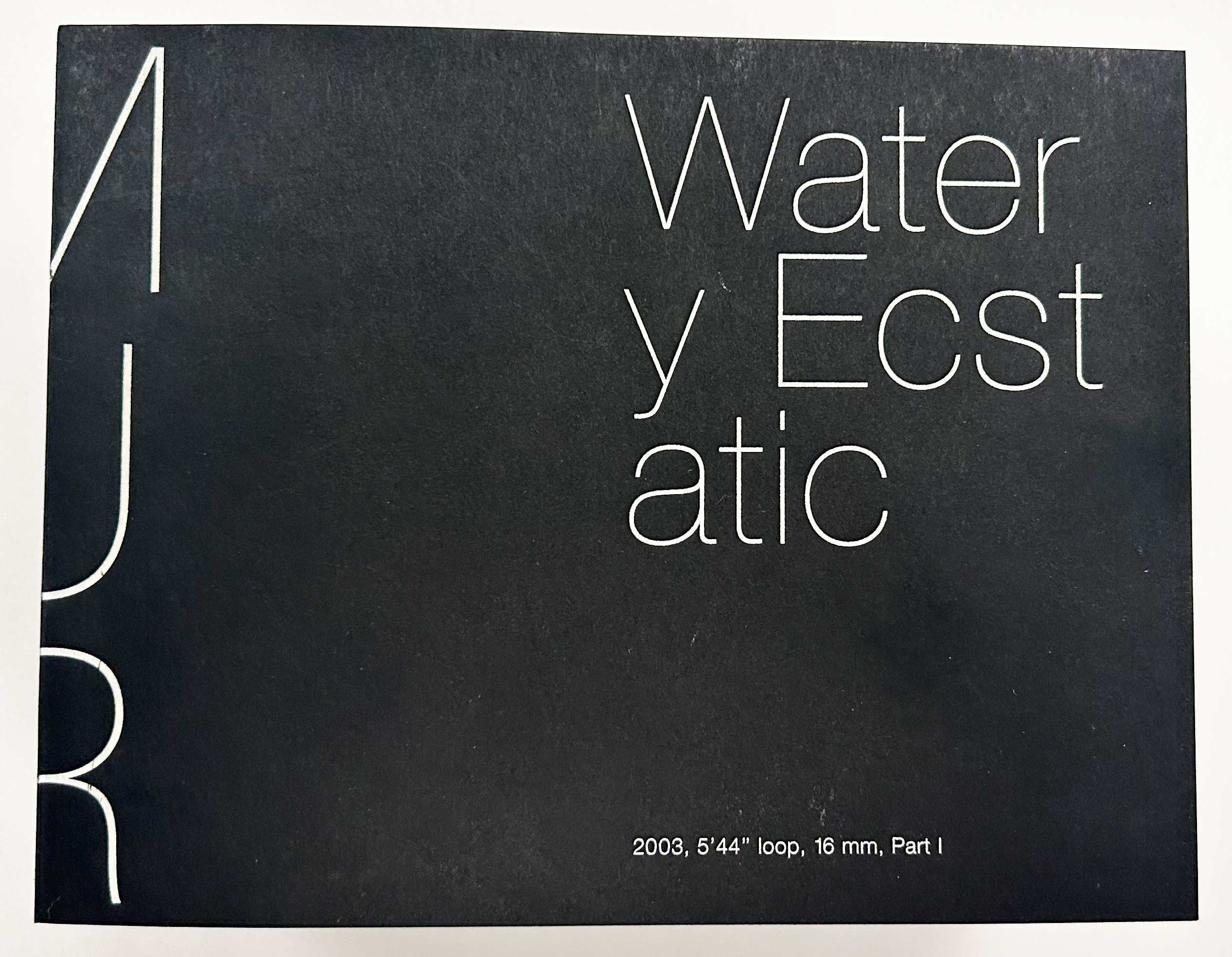 A black cover with the words "Mur" in white on the book's spine, along with white text reading, "Water y Ecst Atic, 2003 5'44' loop, 16mm, Part 1."