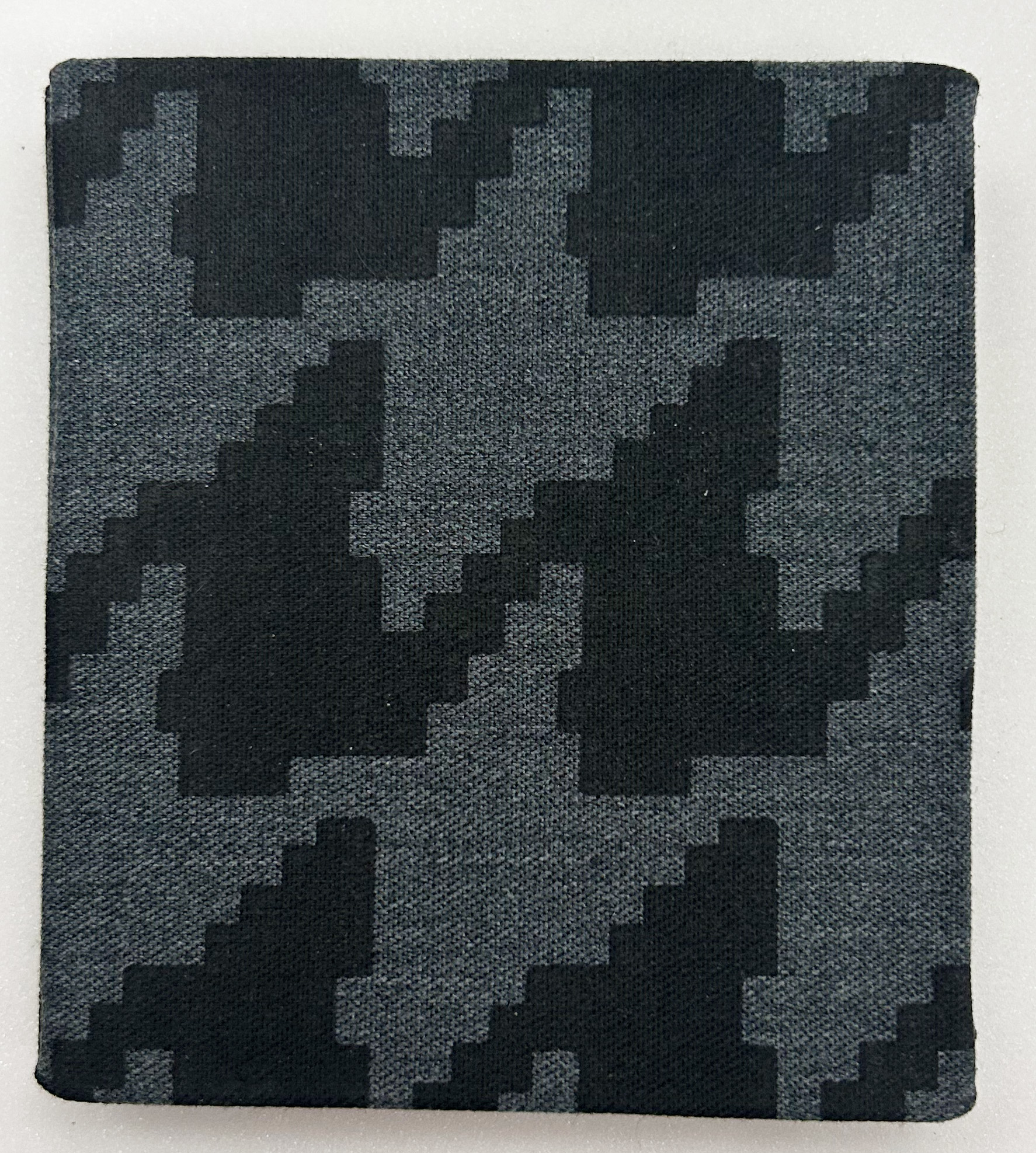 A patterned grey and black cloth cover. 