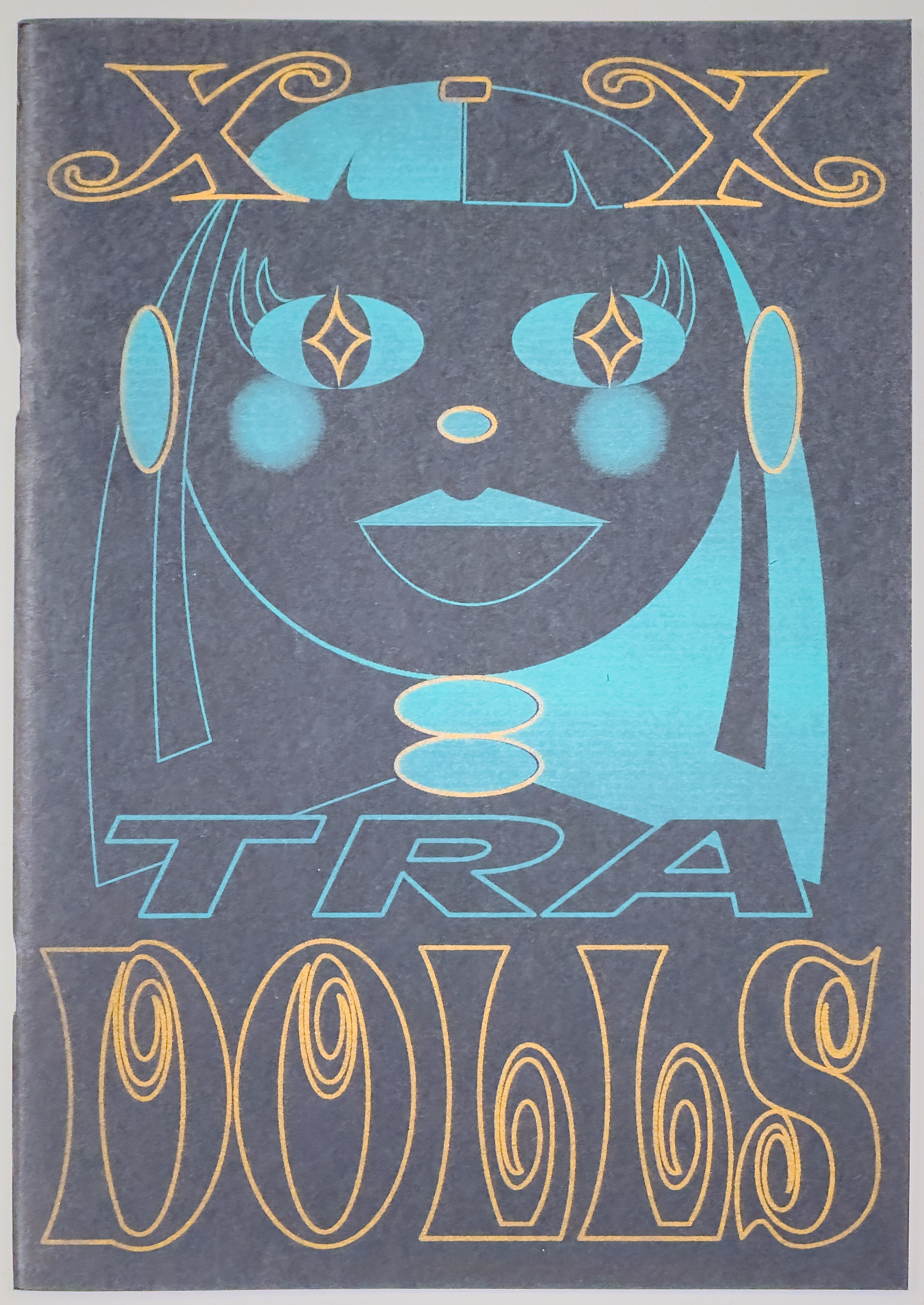 dark grey cover with a black and blue cartoon graphic outline of a girl doll along with the title in blue and orange