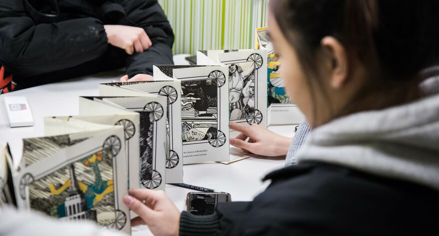 Students looking at artist books in the archives office.