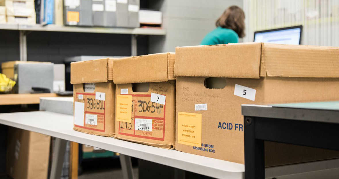 Acid-free boxes holding archival material on a table in the archives.