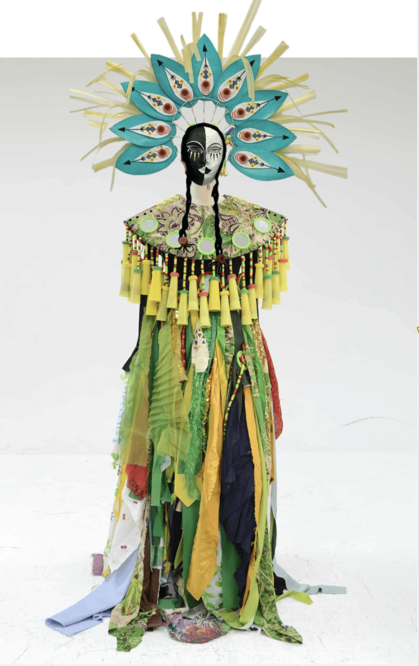 Green and yellow costume with hanging tassels and a large mask