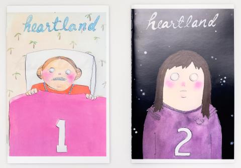 The 1st issue with hand-drawn blue text on top reading, "Heartland," on a tan wallpaper background with repeated palm trees, has a ginger girl on the cover, in her pink bed sheets, with two buns in her hair with an uneasy facial expression. The 2nd issue is with hand-drawn white text on top reading, "Heartland," on a black background with some greyish-white dots spread throughout it. There's a brunette girl in a purple sweater with an uneasy, shocked facial expression on the cover.